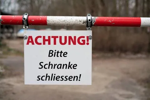 Bitte Schranke schließen Schild mit den Worten ?Achtung bitte Schranke sch.. Stock Photos