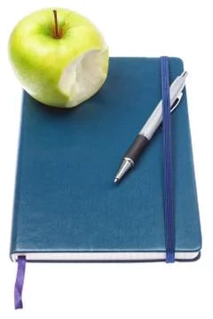 Bitten apple on notepad notebook and ballpoint pen. On a white background. Stock Photos