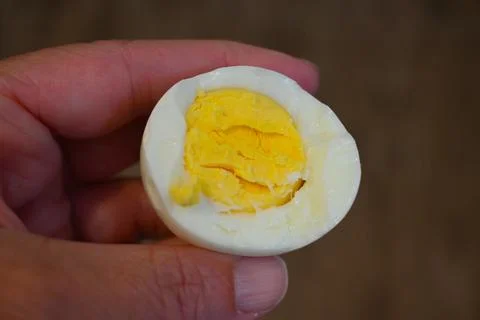 Bitten boiled egg in hand close-up Fotos Stock