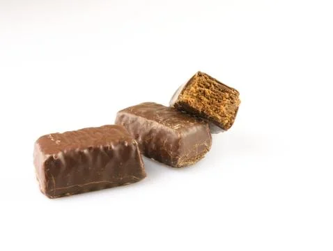 Bitten chocolate candy on a white background. Stock Photos
