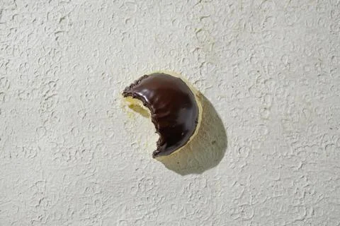 Bitten mini donut with a bite mark visible, set against a textured white ba.. Stock Photos