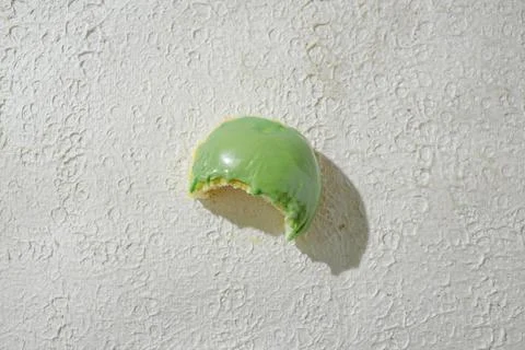 Bitten mini donut with a bite mark visible, set against a textured white ba.. Stock Photos