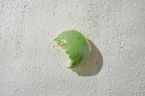 Bitten mini donut with a bite mark visible, set against a textured white ba.. Stock Photos