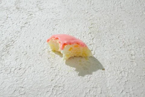 Bitten mini donut with a bite mark visible, set against a textured white ba.. Stock Photos