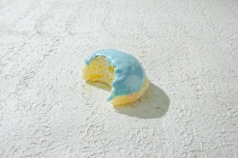 Bitten mini donut with a bite mark visible, set against a textured white ba.. Stock Photos