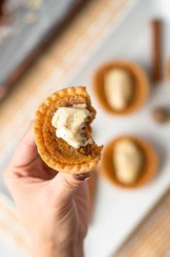 Bitten mini sugar pie in hand. Stock Photos