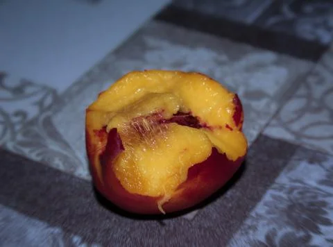Bitten peach on the table Foto stock