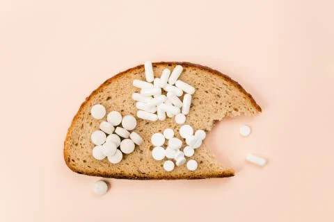 Bitten a piece of bread with a set of vitamins and trace elements. 写真素材