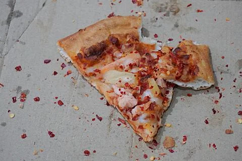 Bitten pizza slice and pepperoni on paper box. Universal food Stock Photos