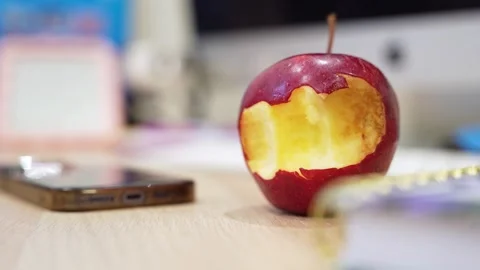 Bitten Red Apple on Modern Office Desk Stock Footage 335951085