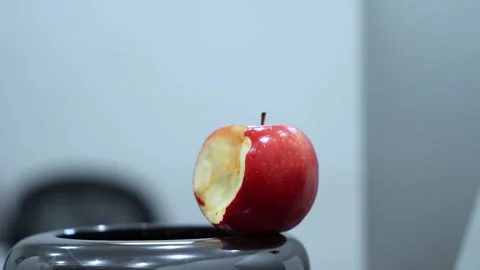 Bitten red apple in modern office interior Stock Footage 336643903