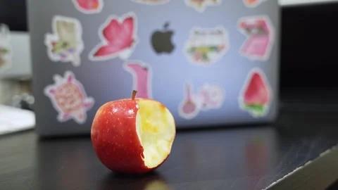 Bitten Red Apple Near Apple MacBook Desk Stock Footage 336593464