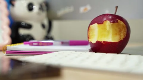 Bitten red apple on office desk Stock Footage 334719995