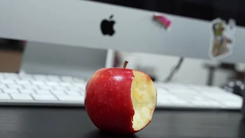 Bitten Red Apple on Office Desk with iMac Stock Footage 336597314