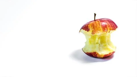 A bitten red red apple on a light background. Stock Photos