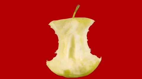 Bitten off ripe yellow apple, core, rotates on a colored red background. Stock Footage 162404988