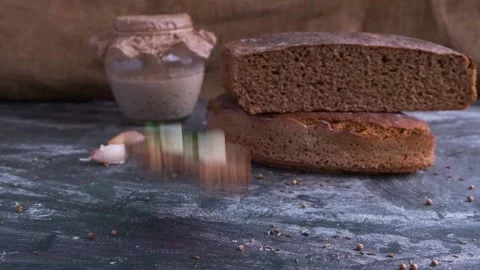 Bitten sandwich bread with onion and garlic fall down on table in slow motion Видео 130495454