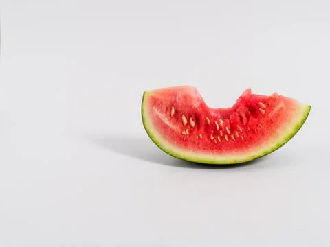Bitten slice of watermelon on white background. Stock Photos