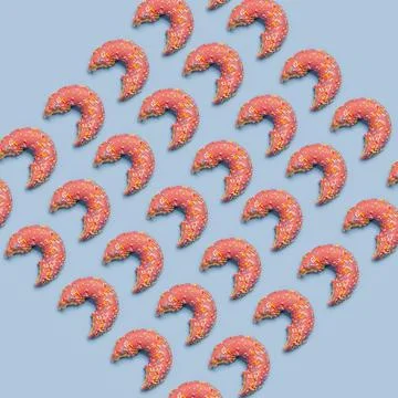 Bitten strawberry donuts pattern on blue background. Stock Photos
