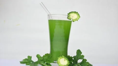 Bitter gourd or bitter melon juice on white background. Видео 330114203