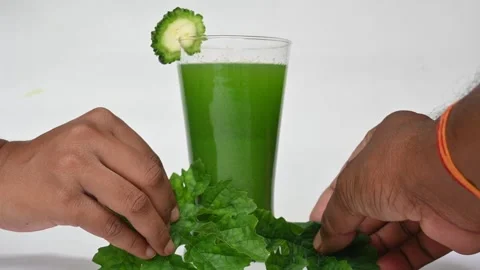 Bitter gourd or bitter melon juice on white background. Видео 330114685