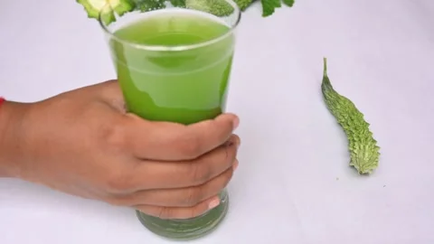 Bitter gourd or bitter melon juice on white background. Видео 330115398