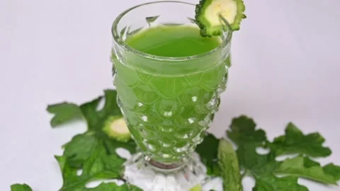 Bitter gourd or bitter melon juice on white background. Видео 330209424