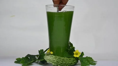 Bitter gourd or bitter melon juice on white background. Видео 330209443