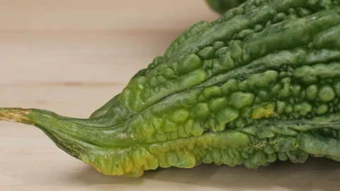 A bitter gourd, a vegetable often used as an ingredient in cuisine, is placed on Stock Footage 277418703