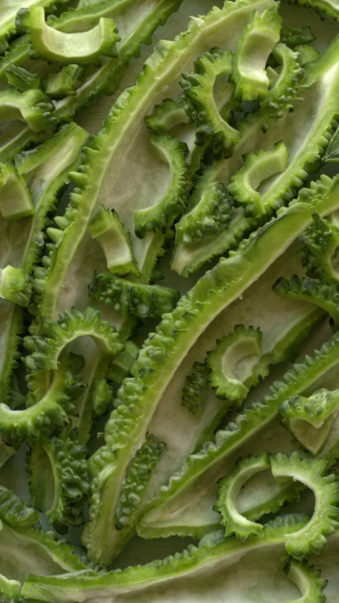Bitter melon texture close up with sliced bitter gourd halves. Video stock 345610480