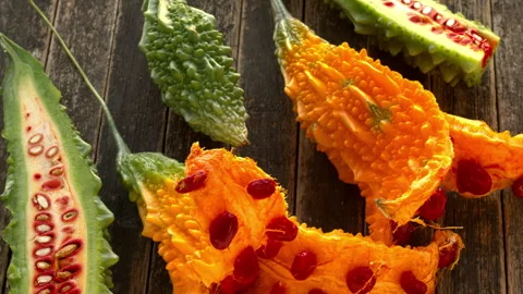 Bitter melons at different stages of ripeness with red seeds. Video stock 345610882