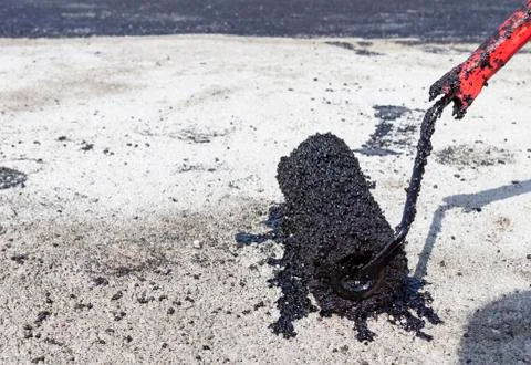 Bitumen on a concrete surface with a roller, waterproofing. close-up.copyspac Stock Photos