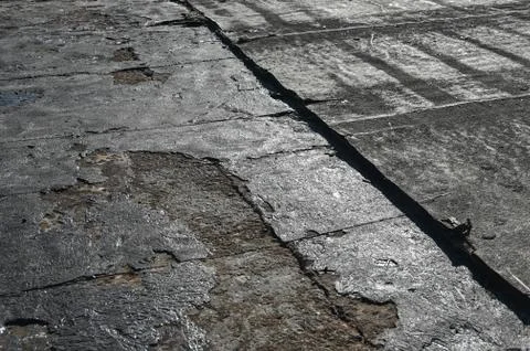 Bitumen flat roofing renovation, background texture of removed damaged Stock Photos