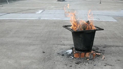 The bitumen melted on the bucket by fire for roofing roof repair Stock Footage 132190767