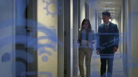 Biz pair walking from far hall end woman consulting folder for review blue tech Stock Footage 332844290