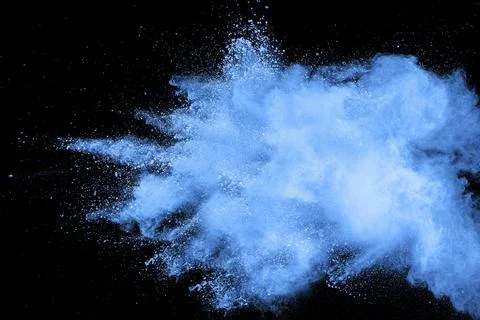 Bizarre forms of blue powder explode cloud on background. Launched blue dust Stock Photos