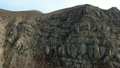 Bizarre forms of rocky mountain slopes overgrown with sparse plants. Aerial view Stock Footage 151140466