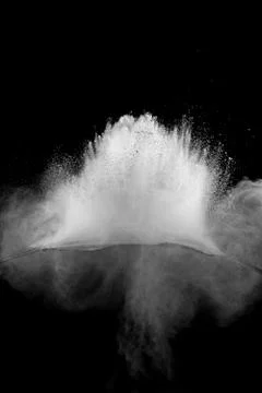 Bizarre forms of white powder explosion cloud against black background. Stock Photos