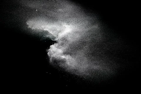 Bizarre forms of white powder explosion cloud against black background. Stock Photos