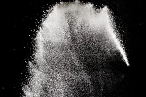 Bizarre forms of white powder explosion cloud against black background. Stock Photos