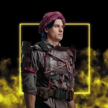 Bizarre guy dressed in armor and headwear against yellow background 库存照片