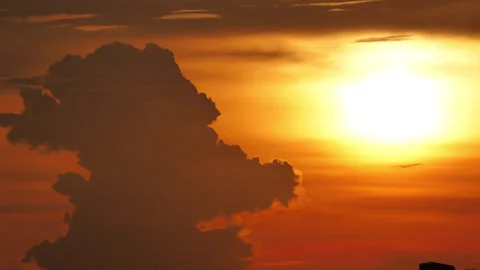 Bizarre head shaped towering cloud transforming beside glowing sunset sun Stock Footage 346162395
