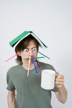 Bizarre man with pencils, book and coffee Stock Photos