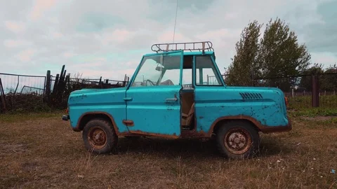 A bizarre old retro aqua-colored car on a meadow. Stock Footage 114326063