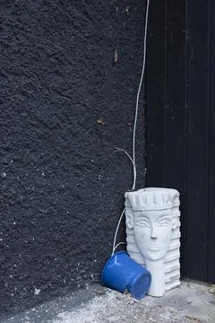 Bizarre still life with a sphinx from the hardware store and a blue bucket Foto stock