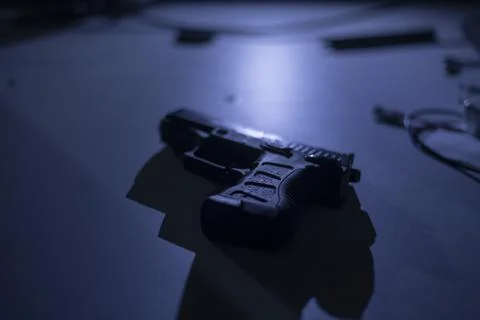 Black 9mm pistol gun on the table in dark room, plan to make a crime or terror Stock Photos