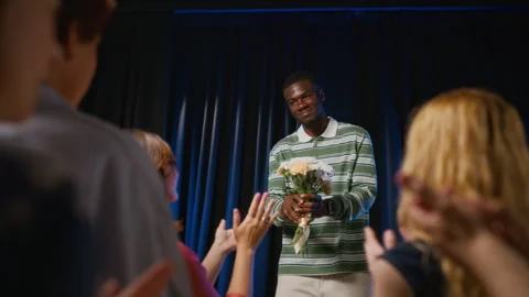 Black Actor Receiving Flowers on Stage from Applauding Audience Stock Footage 344520350