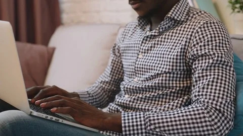 Black african american man using laptop on couch in the living room. Stock Footage 77273901