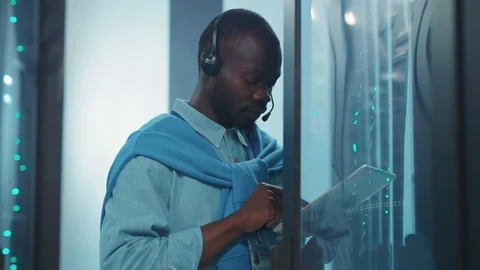 Black african IT technician with tablet examining open rack cabinet with 動画素材 119783229