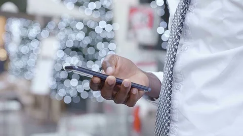 Black african man's hand using smartphone in the street at christmas time Stock-Footage 121408281